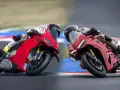 Due superbike Ducati rosse sfrecciano in pista, piegando in curva con maestria.