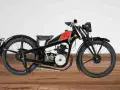 Una rara moto d'epoca, nera con serbatoio rosso e logo, su un pavimento di legno.