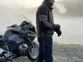 Motociclista con giacca tecnica e jeans, pronto per un'avventura. Ecco come vestirsi per andare in moto in ogni condizione.