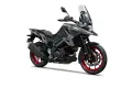 Suzuki V-Strom 1050 grigia con dettagli rossi sui cerchi, pronta per l'avventura.