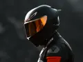 Casco da moto integrale nero con visiera arancione riflettente, pronto per la pista.