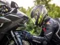 Motociclista con casco AGV e tuta Dainese, dettagli sul materiale caschi moto e la sua aerodinamica.