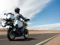 Motociclista con abbigliamento tecnico, ideale per capire come vestirsi in moto d'estate, viaggia su una Suzuki con borse laterali e posteriori.
