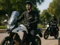 Uomo alto 1.90 in sella a una moto da turismo bianca, con un altro motociclista sullo sfondo.