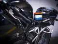 Una batteria nuova va caricata. La nuova batteria Exide è posizionata sul telaio di una moto nera lucida, pronta per essere collegata.