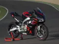 Aprilia RS 457, una moto sportiva nera con grafiche rosse e blu, pronta a sfrecciare su un circuito.