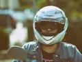 Persona con casco jet, non un demi-jet, pronta per un giro in moto. La differenza è nella copertura.
