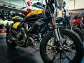 Una moto gialla e nera, con altre moto in esposizione. Diversi tipi di moto pronti per essere scelti.