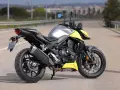 Honda CB 750 Hornet grigia e gialla parcheggiata su strada.