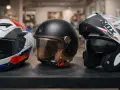 Tre caschi moto: uno sportivo bianco/rosso/blu, uno jet nero vintage e uno modulare bianco/nero. Tutti con omologazione casco E3.