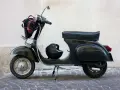 Moto d'epoca, un classico intramontabile. Dopo quanti anni mantiene ancora il suo fascino? Un casco e una borsa completano il look.