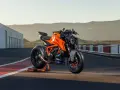 KTM 1290 Duke arancione su un cavalletto, pronta per sfrecciare su un circuito al tramonto.