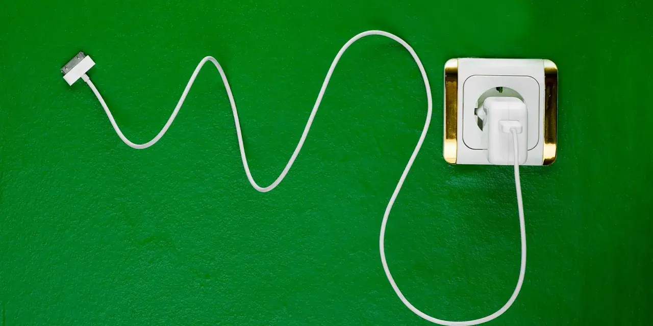 Cavo bianco collegato a una presa elettrica dorata. Si può lasciare il caricabatterie attaccato per avere sempre energia.