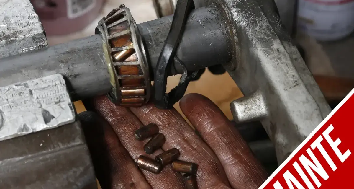 Manutenzione albero motore T-Max: cuscinetto usurato e rullini sparsi nella mano.