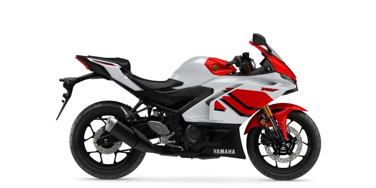 Yamaha R3, moto sportiva bianca e rossa, leggera e agile, perfetta per chi cerca prestazioni e divertimento. Il suo peso contenuto la rende ideale per la città e le curve.