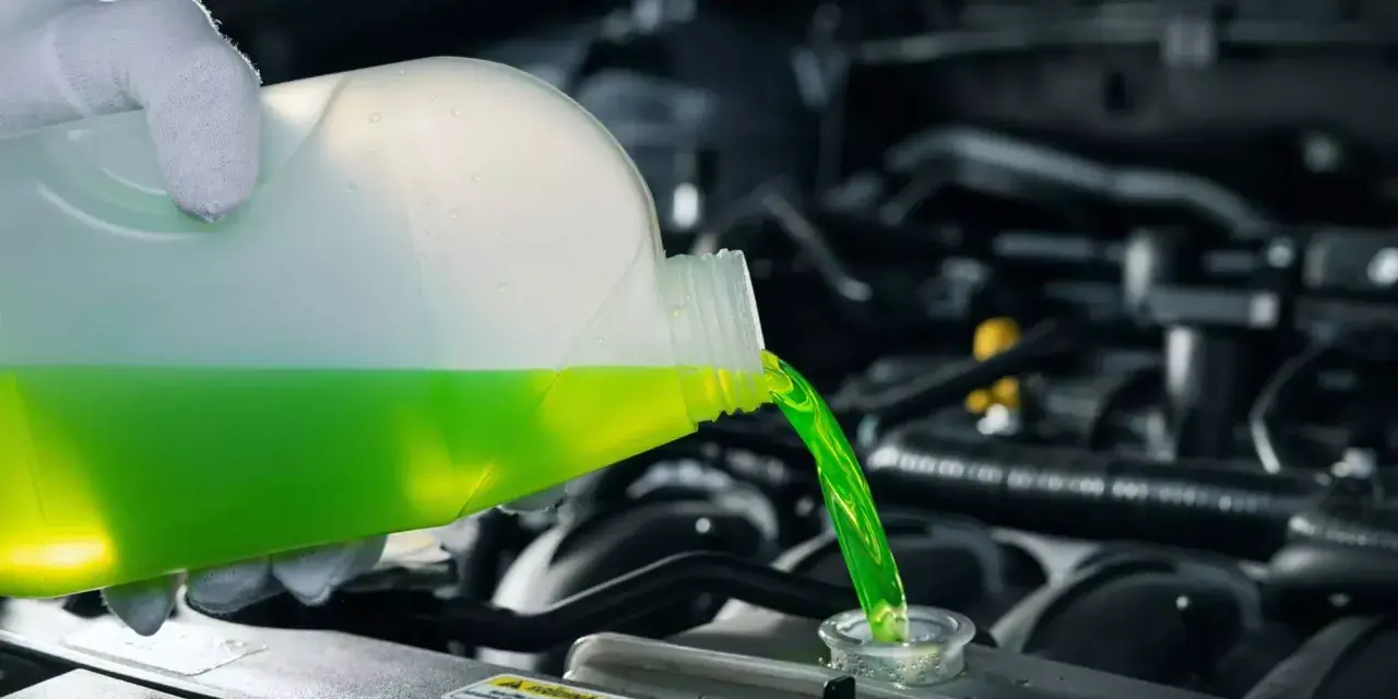 Versamento di liquido refrigerante verde in un radiatore. Le cause di un radiatore senza acqua possono essere perdite o evaporazione.