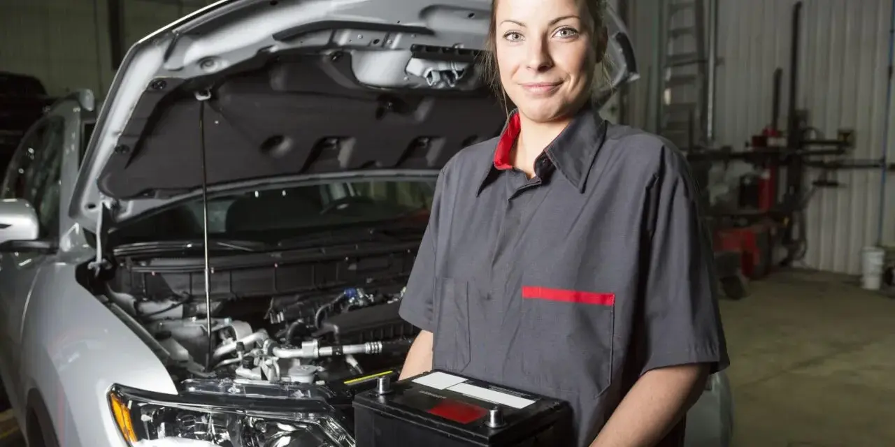 Meccanica sorridente con una nuova batteria, pronta per mostrare come montare una batteria auto.