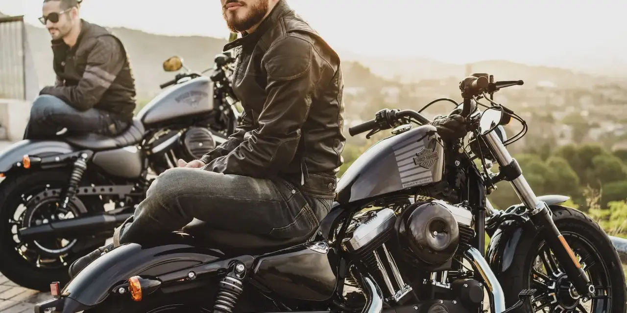 Due motociclisti con giacche di pelle e jeans, pronti per un viaggio. L'abbigliamento del motociclista è essenziale per la sicurezza e lo stile.