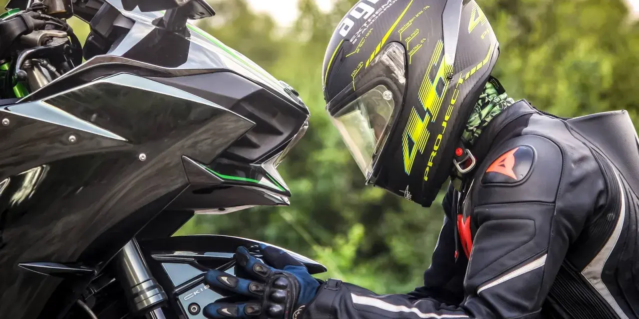 Motociclista con casco AGV e tuta Dainese, dettagli sul materiale caschi moto e la sua aerodinamica.