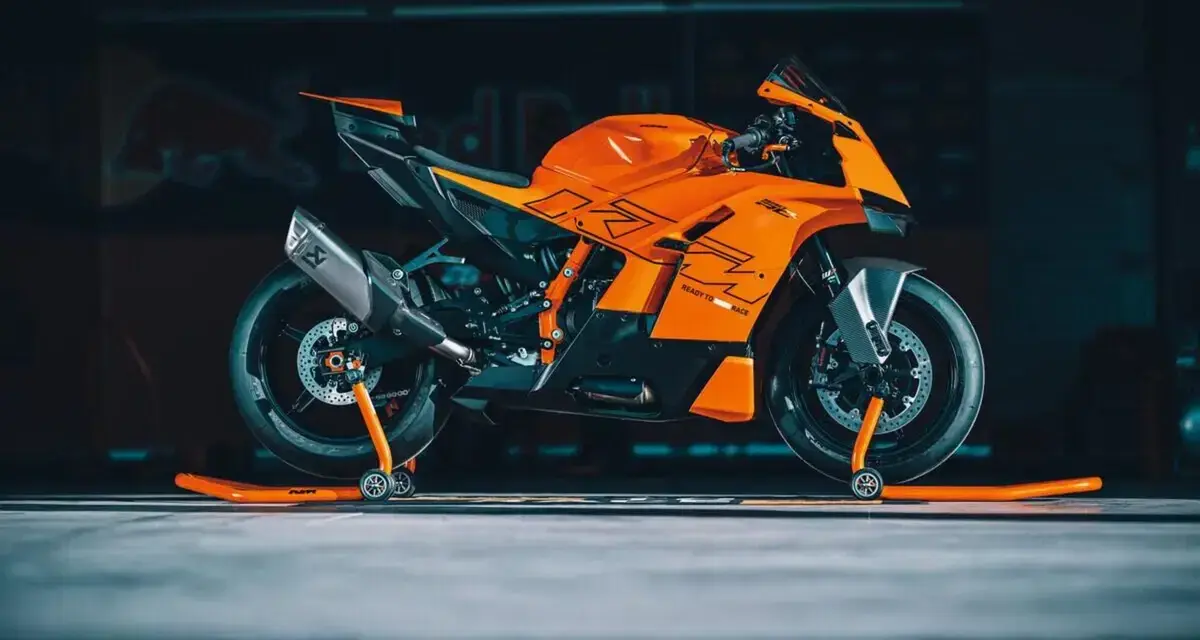 La KTM 890 Duke GP, arancione e nera, pronta per la pista, con scarico Akrapovič e cavalletti arancioni.