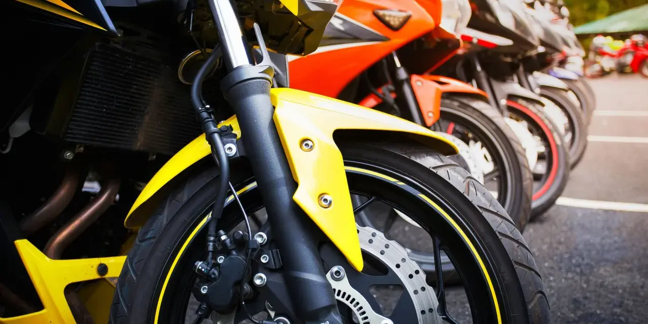 Una fila di moto sportive, tra cui una Yamaha scarenata gialla in primo piano, pronte per la corsa.