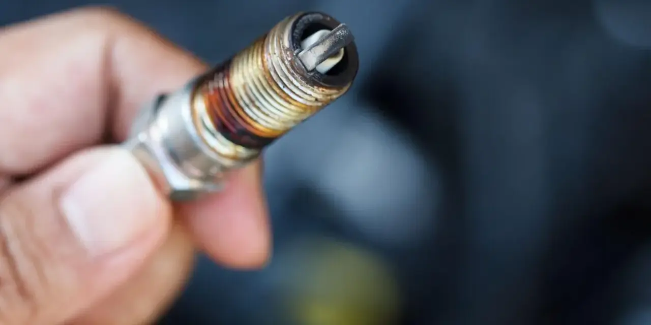 Candela sporca e usurata, un chiaro segnale su come capire se le candele sono da cambiare per un motore efficiente.