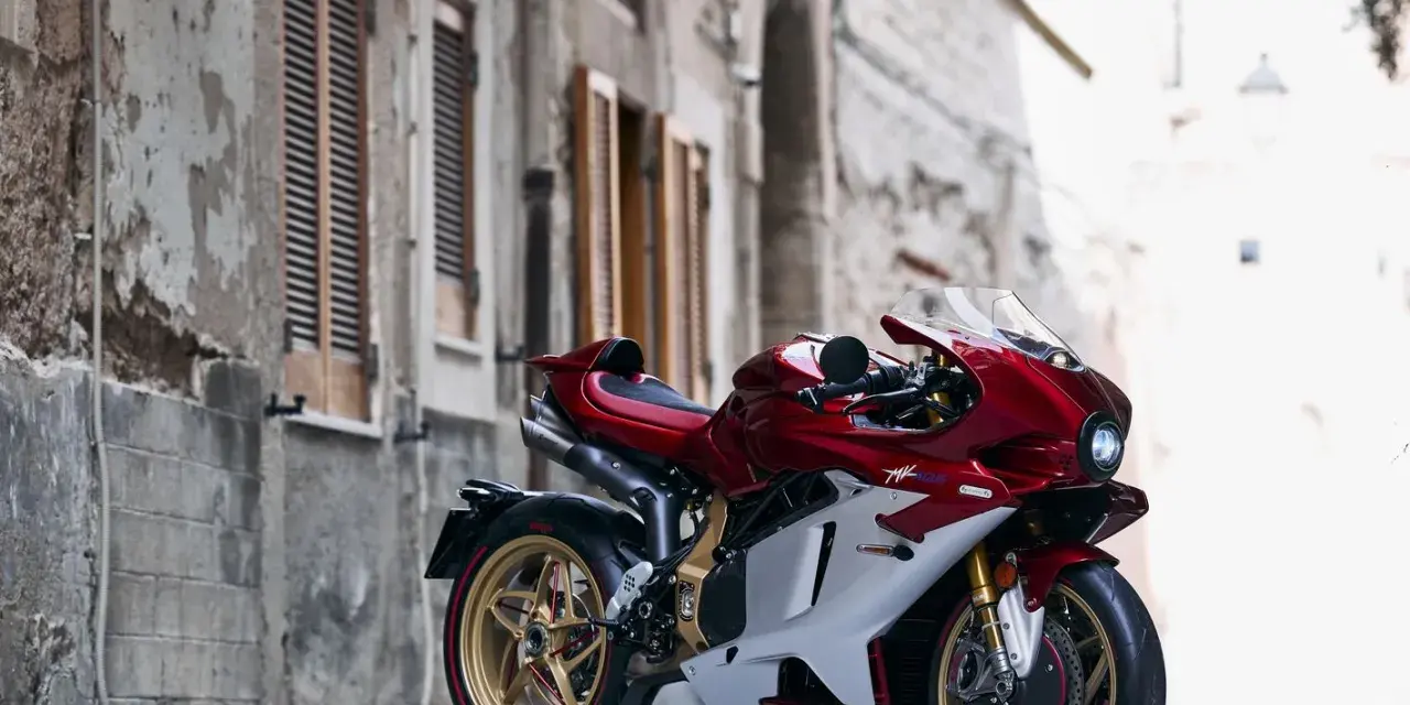 MV Agusta rossa e bianca, la più costosa, su un cavalletto in un vicolo storico.