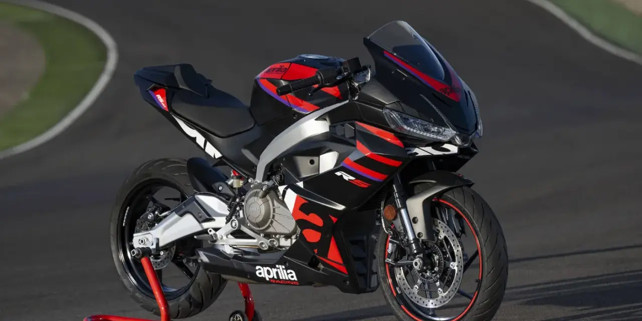 Aprilia RS 457, una moto sportiva nera con grafiche rosse e blu, pronta a sfrecciare su un circuito.