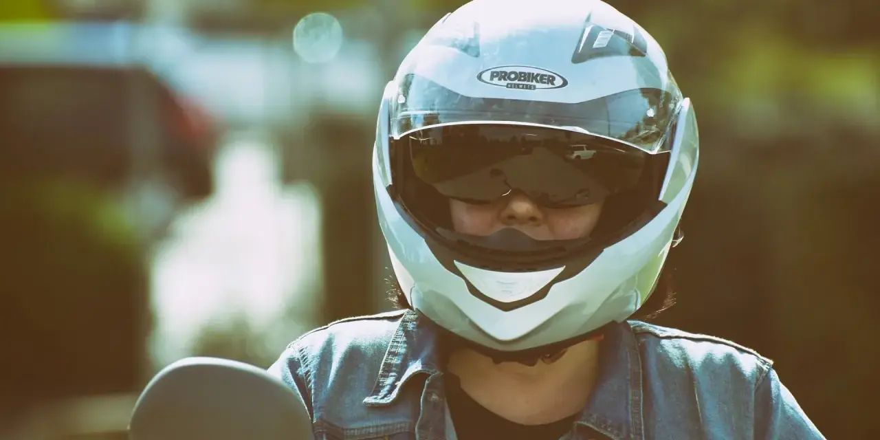 Persona con casco jet, non un demi-jet, pronta per un giro in moto. La differenza è nella copertura.