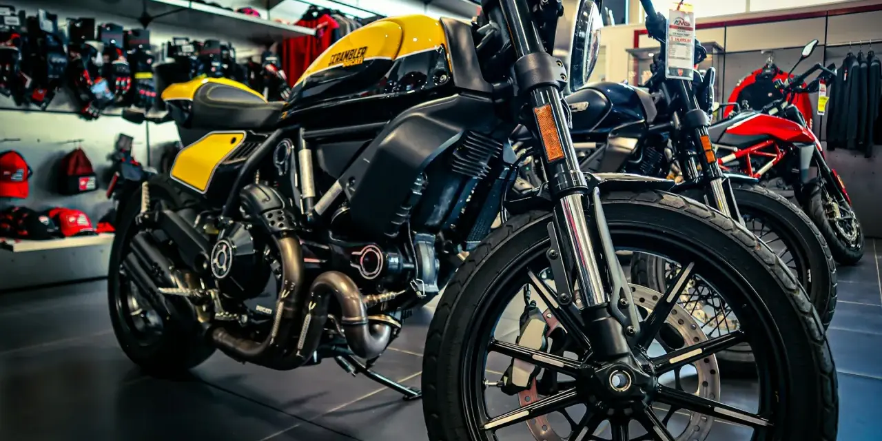 Una moto gialla e nera, con altre moto in esposizione. Diversi tipi di moto pronti per essere scelti.