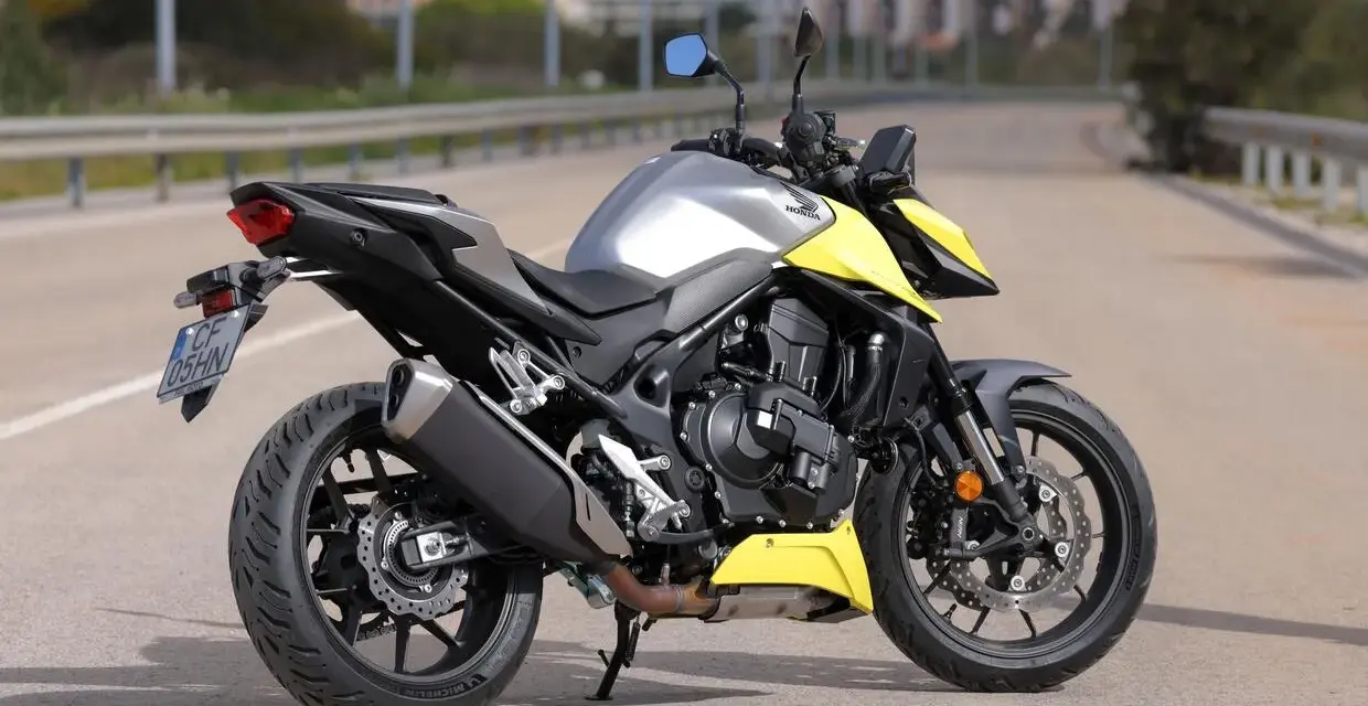 Honda CB 750 Hornet grigia e gialla parcheggiata su strada.