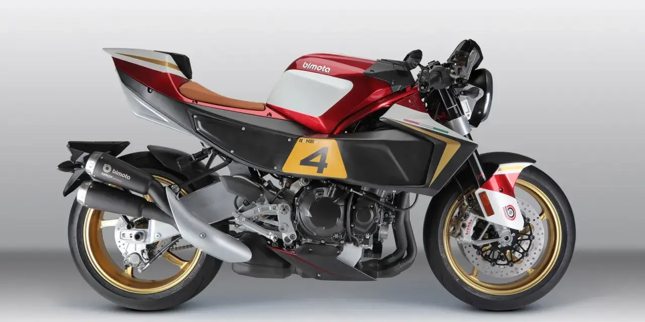La Bimota KB4, una moto sportiva con serbatoio rosso e bianco, sella marrone e dettagli dorati.