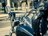Man in leather jacket on motorcycle, dashboard shows alta temperatura eccessiva liquido radiatore.