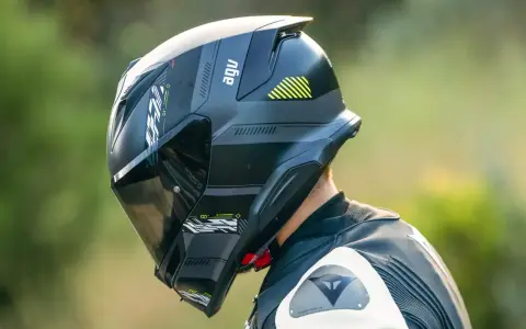 Casco AGV nero con visiera scura, pronto per la pista. Il significato di AGV è passione per la sicurezza e le prestazioni.