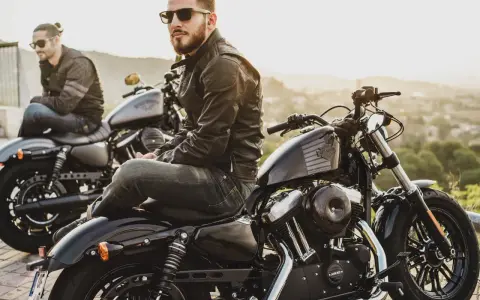 Due motociclisti con giacche di pelle e jeans, pronti per un viaggio. L'abbigliamento del motociclista è essenziale per la sicurezza e lo stile.