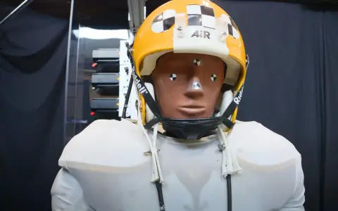 Manichino con casco giallo e bianco, con segni di misurazione, pronto per testare come capire se un casco è omologato.