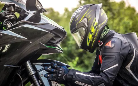 Motociclista con casco AGV e tuta Dainese, dettagli sul materiale caschi moto e la sua aerodinamica.