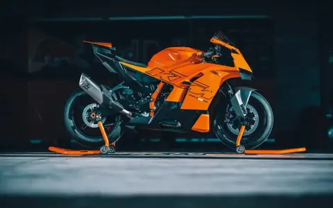 La KTM 890 Duke GP, arancione e nera, pronta per la pista, con scarico Akrapovič e cavalletti arancioni.