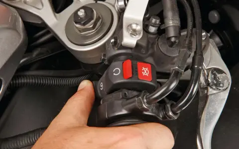 Il motorino gira ma la moto non parte. Il pollice preme il pulsante di accensione, ma il motore resta muto.