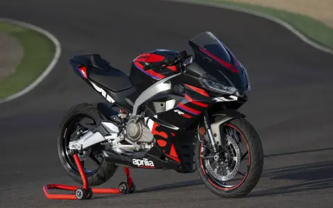 Aprilia RS 457, una moto sportiva nera con grafiche rosse e blu, pronta a sfrecciare su un circuito.