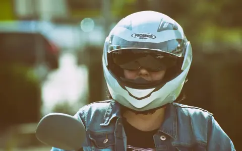 Persona con casco jet, non un demi-jet, pronta per un giro in moto. La differenza è nella copertura.