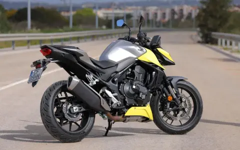 Honda CB 750 Hornet grigia e gialla parcheggiata su strada.