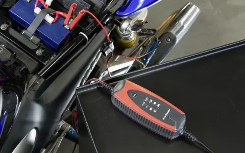 Caricabatterie collegato alla batteria di una moto. Un modo semplice per **come ricaricare le batterie** e ripartire.