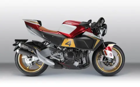 La Bimota KB4, una moto sportiva con serbatoio rosso e bianco, sella marrone e dettagli dorati.