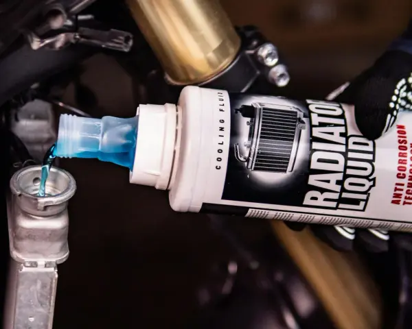 Versando liquido radiatore moto, uguale a quello per auto, nel serbatoio di raffreddamento.