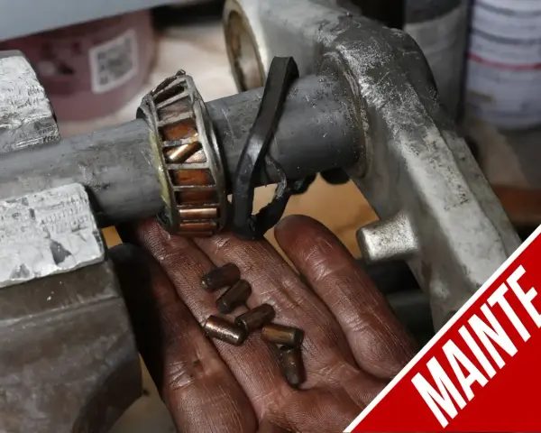 Manutenzione albero motore T-Max: cuscinetto usurato e rullini sparsi nella mano.
