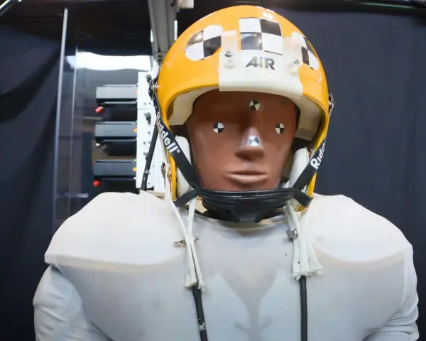 Manichino con casco giallo e bianco, con segni di misurazione, pronto per testare come capire se un casco è omologato.
