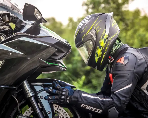 Motociclista con casco AGV e tuta Dainese, dettagli sul materiale caschi moto e la sua aerodinamica.