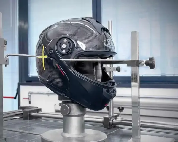 Casco in carbonio in fase di test, con strumenti di misurazione. Verifica della scadenza omologazione casco E3 per garantire la sicurezza.