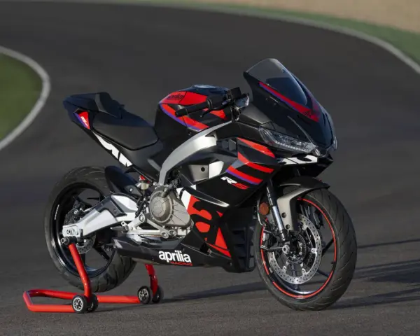 Aprilia RS 457, una moto sportiva nera con grafiche rosse e blu, pronta a sfrecciare su un circuito.